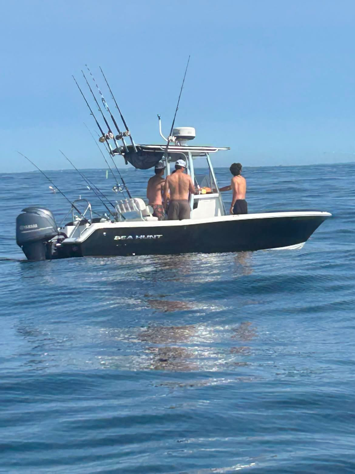 Sea Hunt center console offshore with crew and rods water-level shot