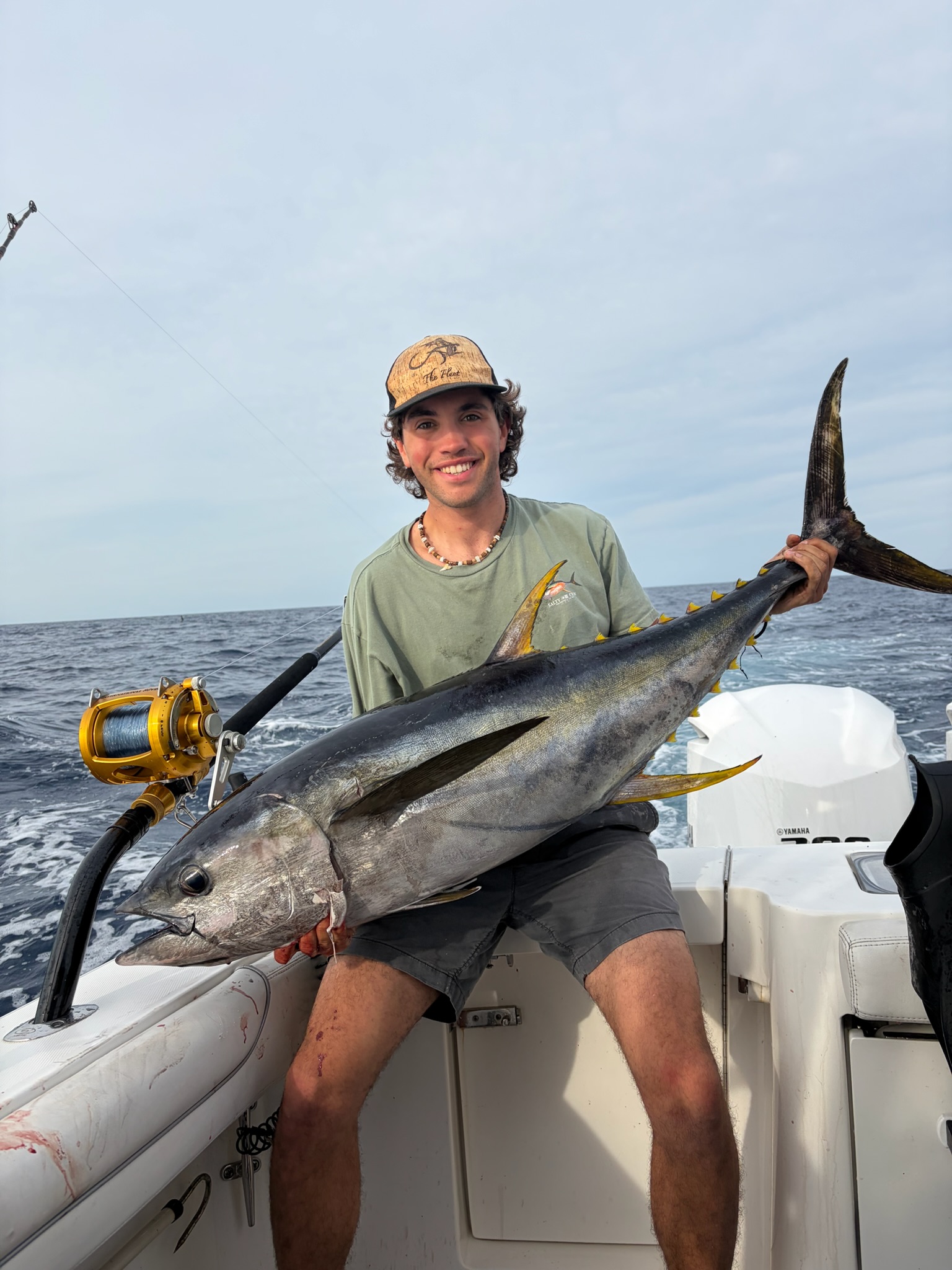 Angler with large yellowfin tuna wearing Fleet hat