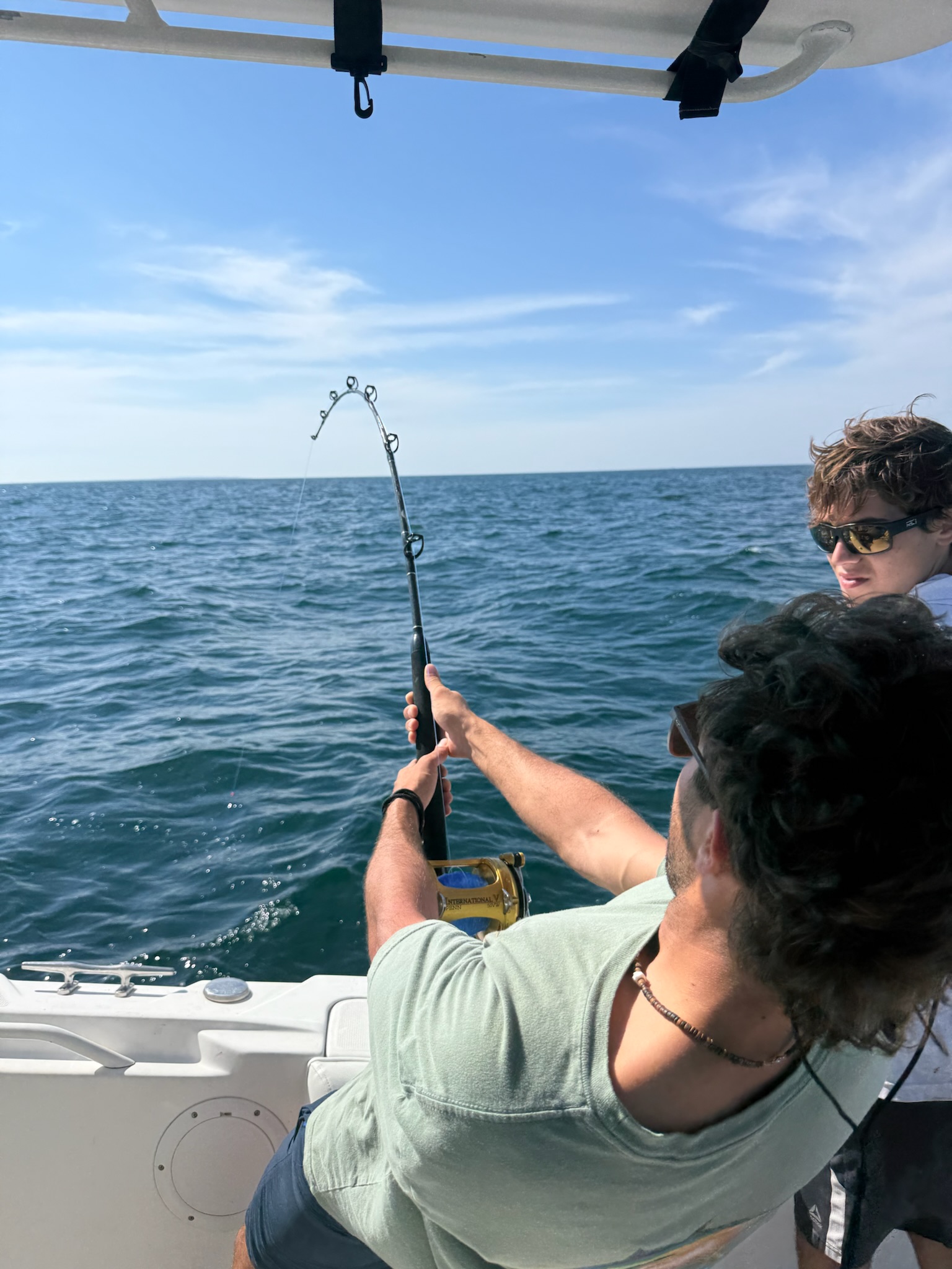 Angler fighting fish with bent rod offshore