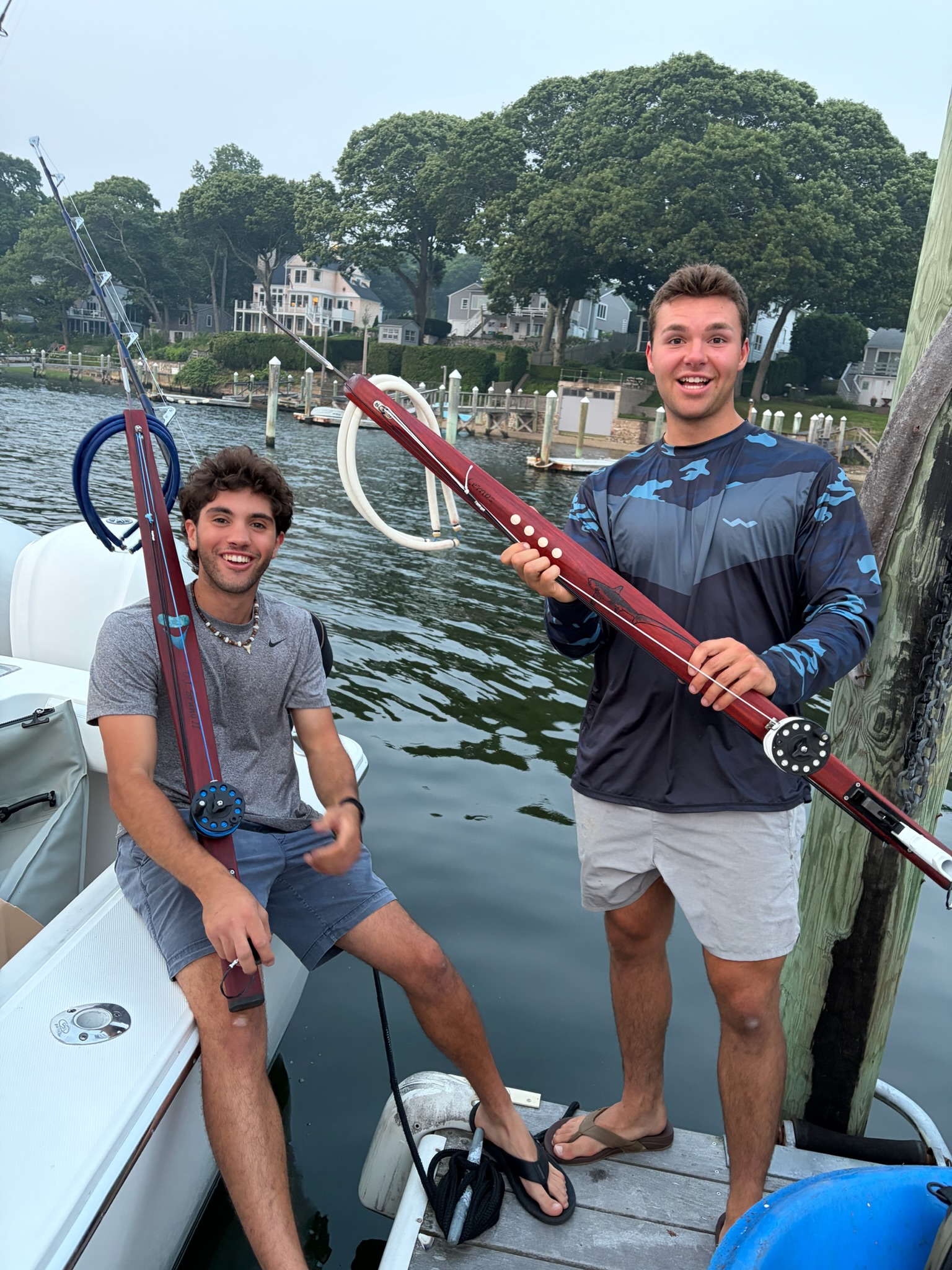 Two crew with spearguns at dock marina