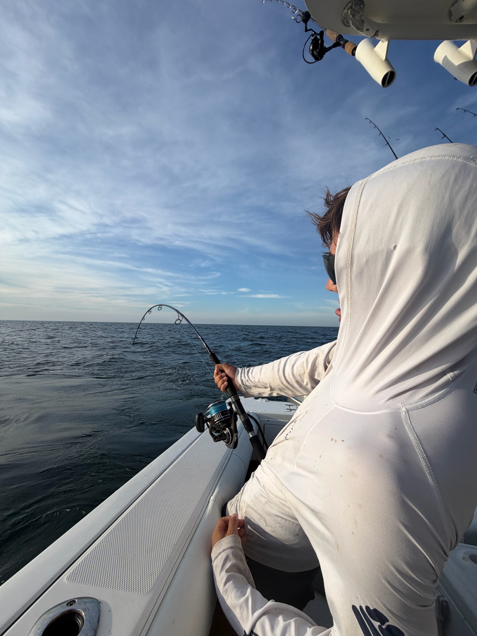 Angler fighting fish with bent spinning rod