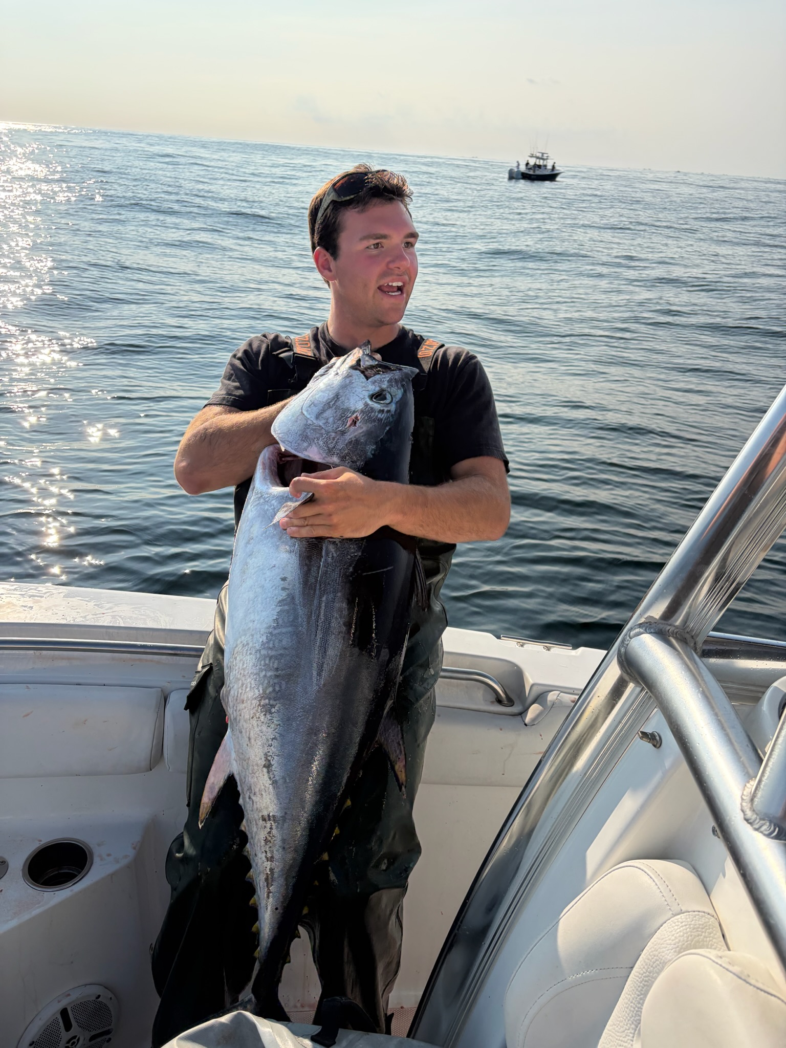 Angler fighting fish with bent rod blue sky