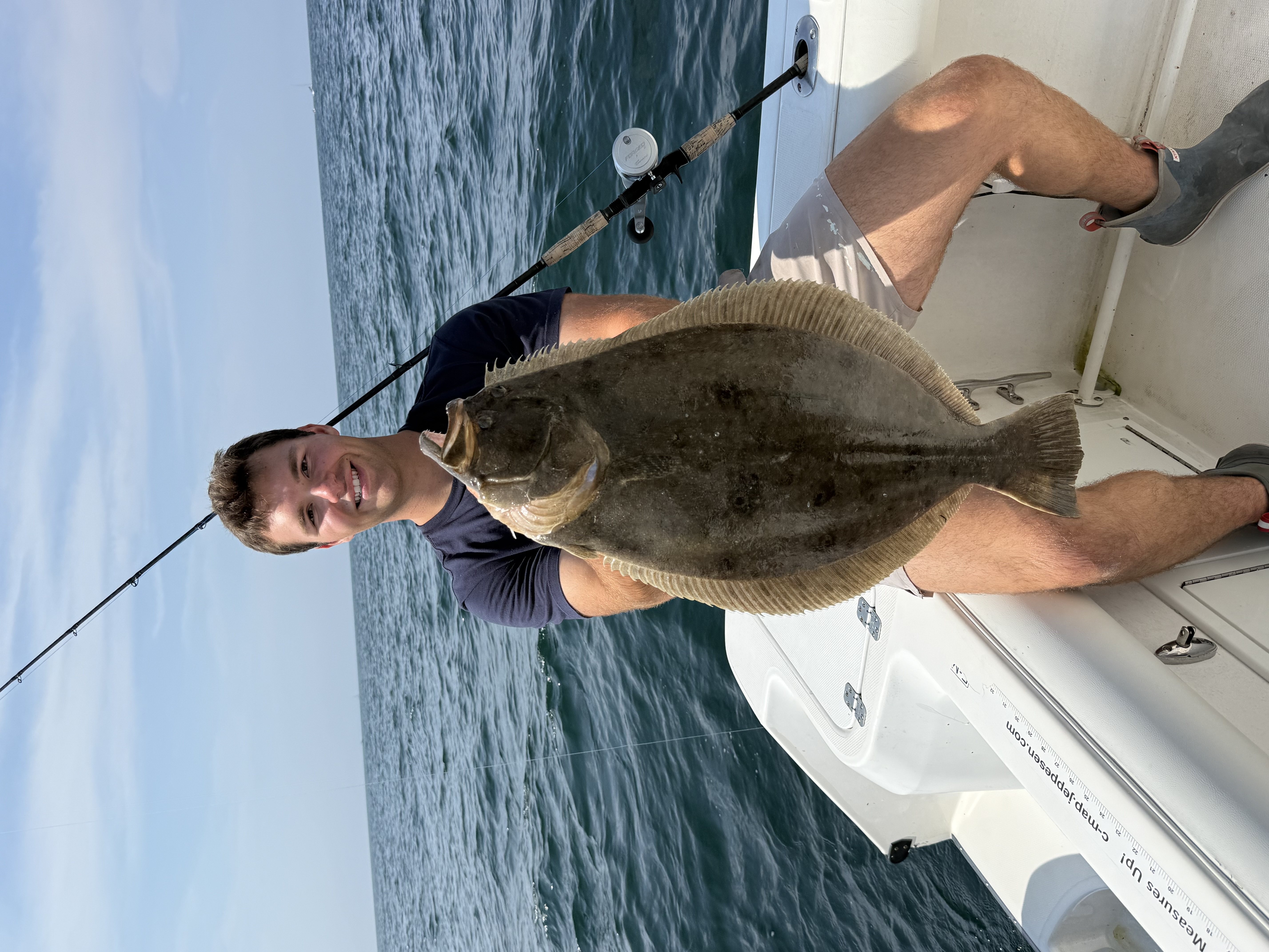 Angler holding large fluke on boat