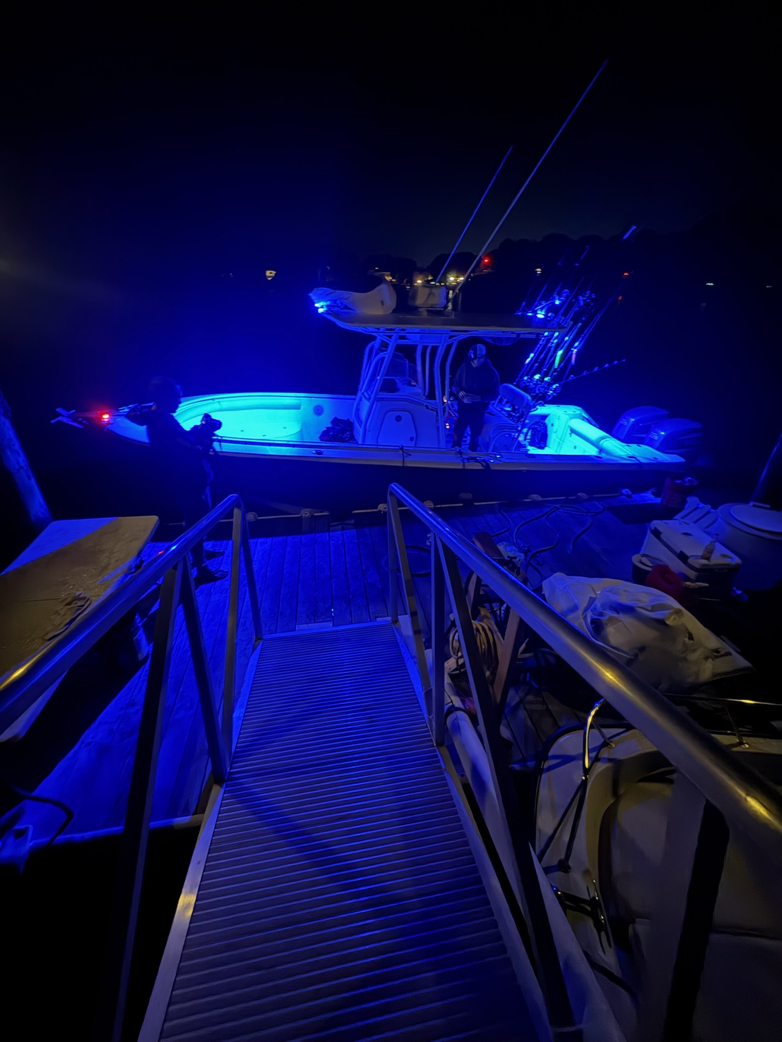 Boat lit with blue LED lights at night dock