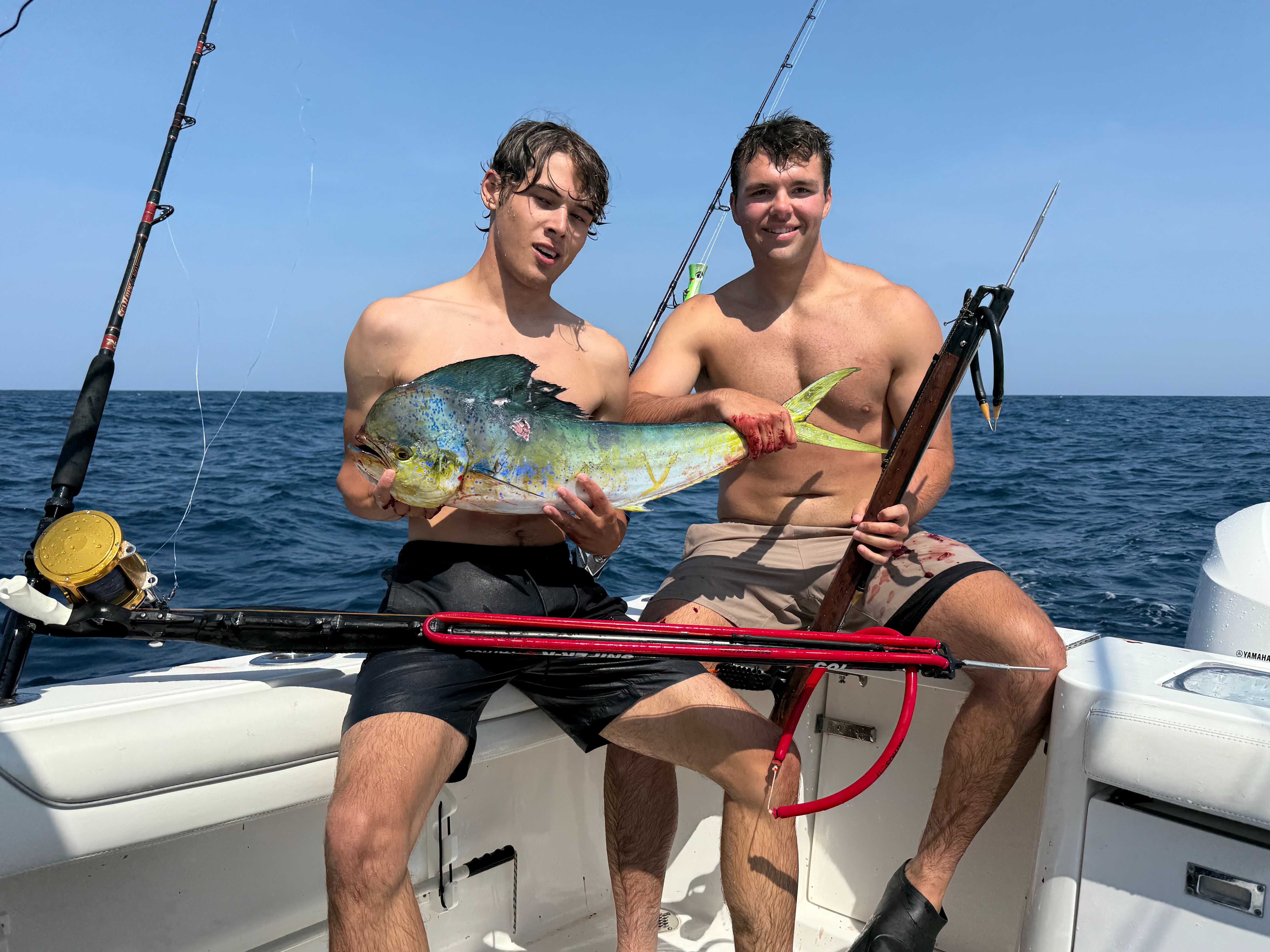 Two anglers with a mahi offshore