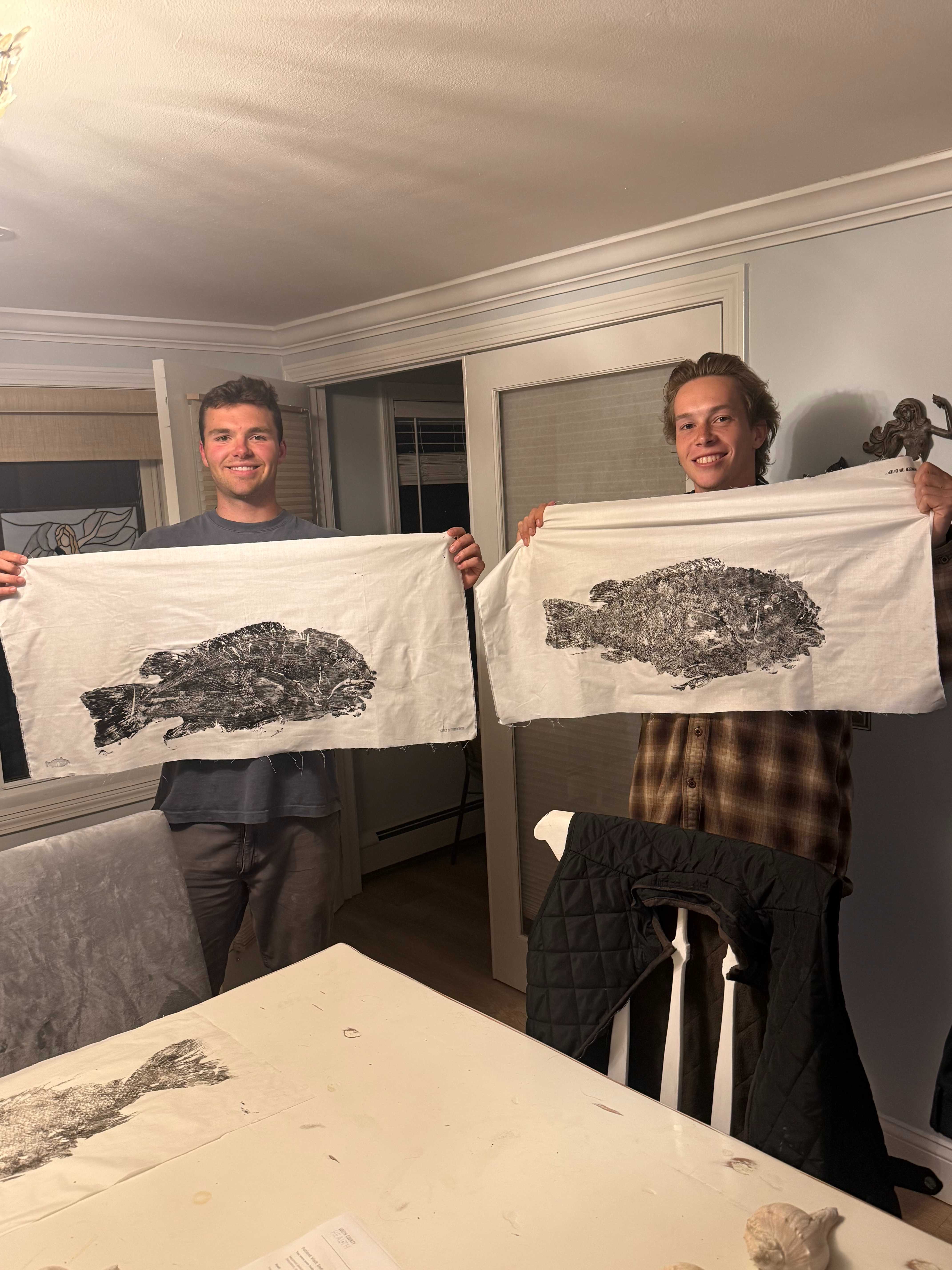 Two anglers holding fish prints